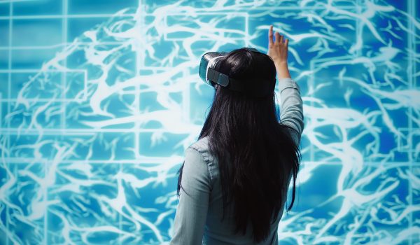 developer-wearing-vr-headset-looking-artificial-intelligence-hologram TITLdeveloper-wearing-vr-headset-looking-artificial-intelligence-hologram